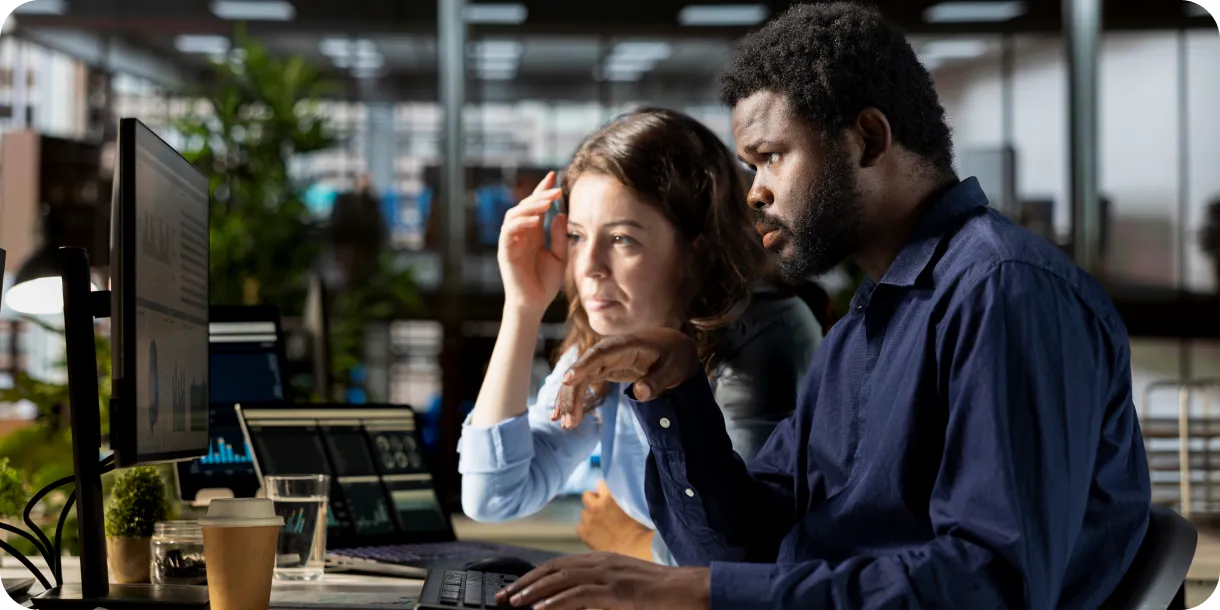 Two colleagues collaborating at a computer in an office