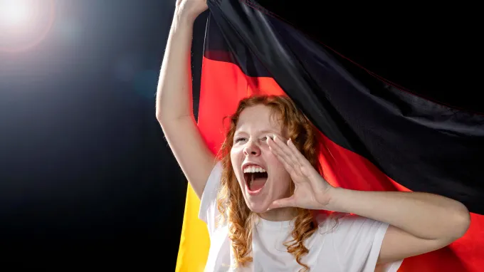 A fan celebrating with a German flag for a Germany dating case study