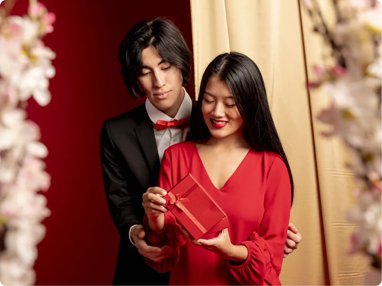 A well-dressed couple exchanging a gift, illustrating a premium dating audience